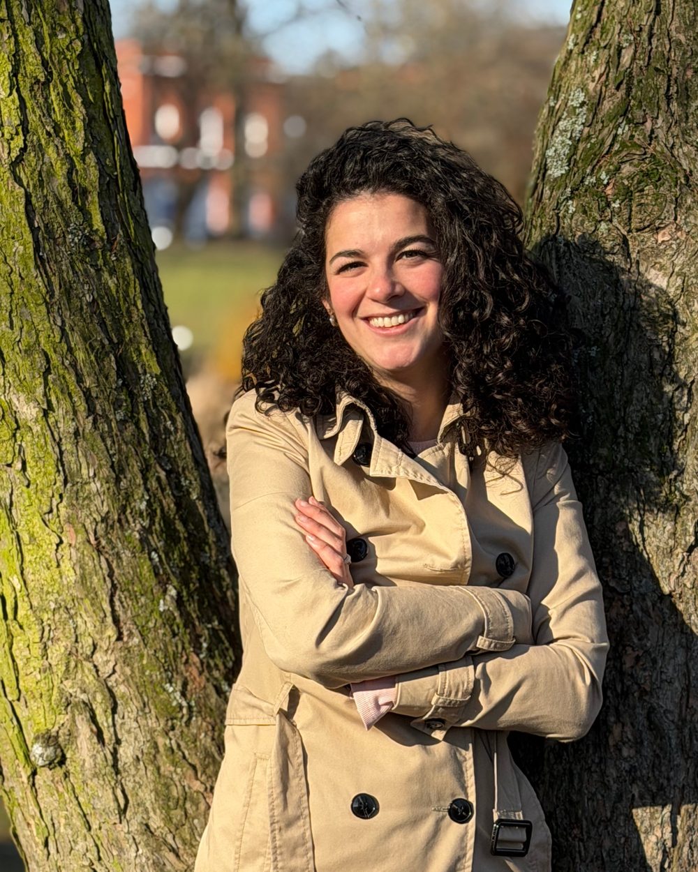 Julika im Trenchcoat an einem Baum